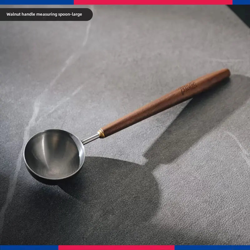 Premium Crop Wooden Handle Coffee Scoop made of stainless steel with a polished wooden grip filled with ground coffee.