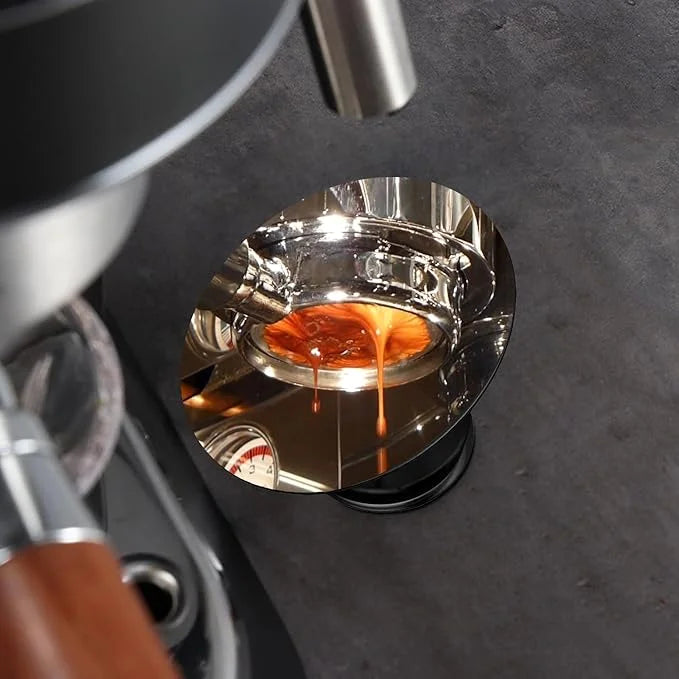 Crop Cafe espresso shot mirror with a reflective oval glass piece mounted on an adjustable black magnetic base.