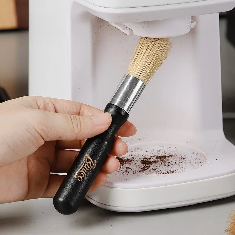 Crop Cafe coffee grinder cleaning brush featuring a sleek ergonomic black wooden handle, silver ferrule, and durable natural bristles.