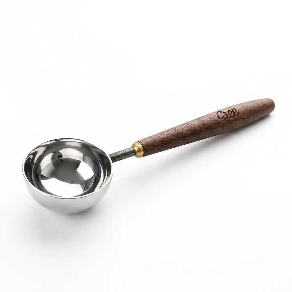 Premium Crop Wooden Handle Coffee Scoop made of stainless steel with a polished wooden grip filled with ground coffee.