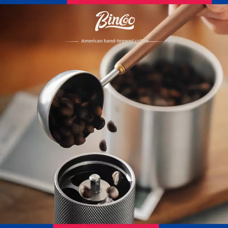 Premium Crop Wooden Handle Coffee Scoop made of stainless steel with a polished wooden grip filled with ground coffee.