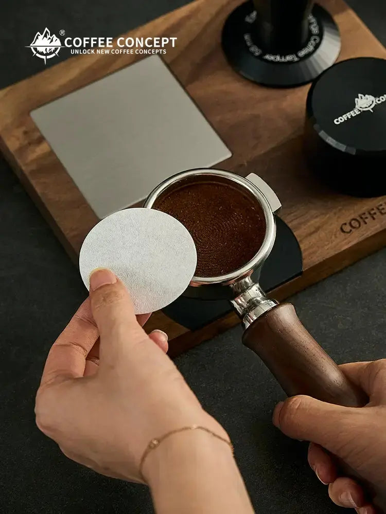 Round paper filter from the 100-Count Espresso Coffee Filter Papers pack placed inside a stainless steel portafilter.