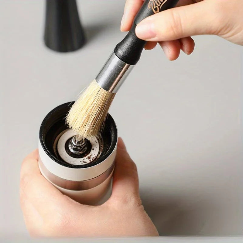 Crop Cafe coffee grinder cleaning brush featuring a sleek ergonomic black wooden handle, silver ferrule, and durable natural bristles.