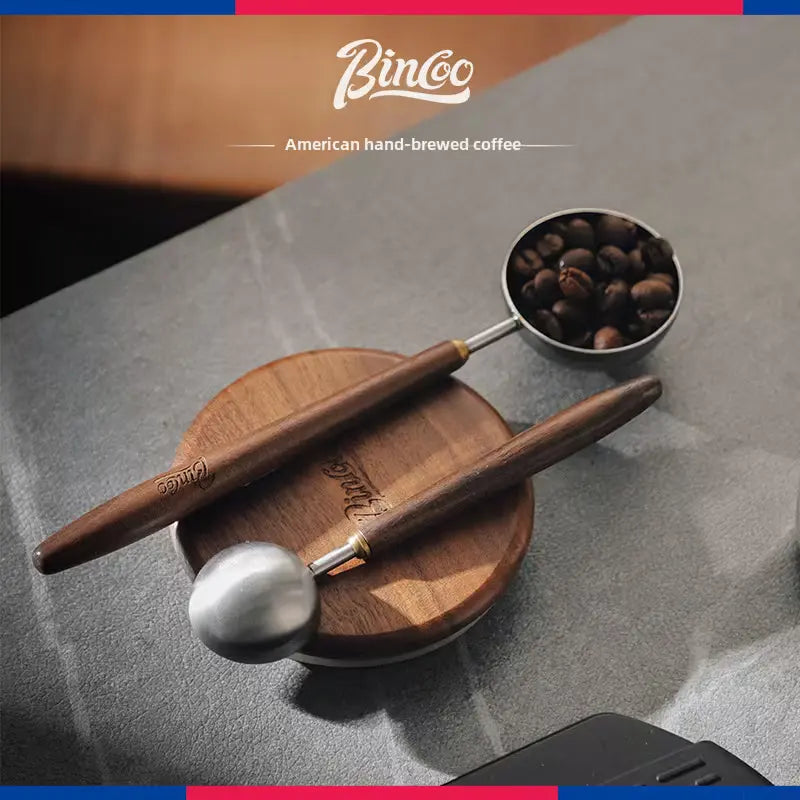 Premium Crop Wooden Handle Coffee Scoop made of stainless steel with a polished wooden grip filled with ground coffee.